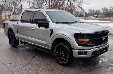A silver 4x4 Ford truck with tinted windows