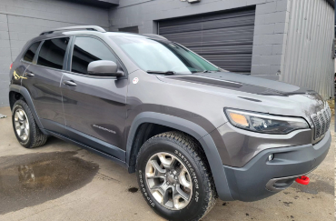 A silver Cherokee with tinted windows