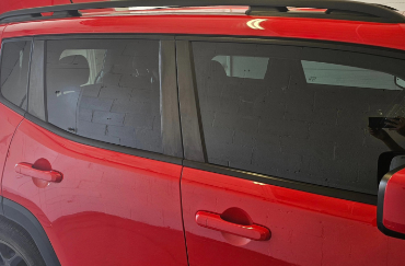 A side view of a red car with tinted windows